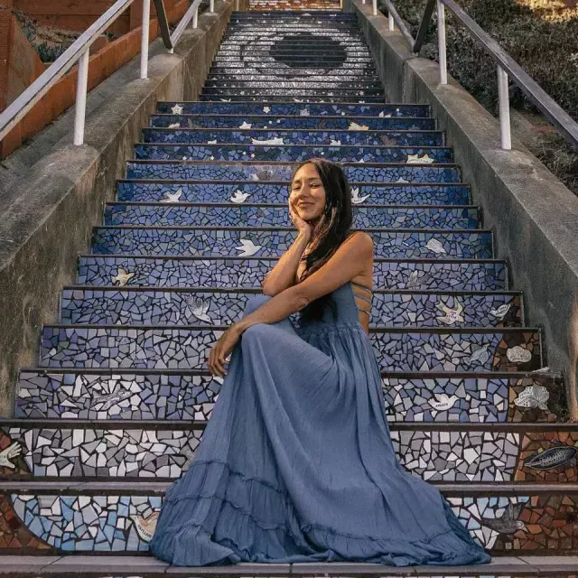 Eine Frau posiert auf der gefliesten Treppe der 16th Avenue im Stadtteil Sunset in San Francisco.